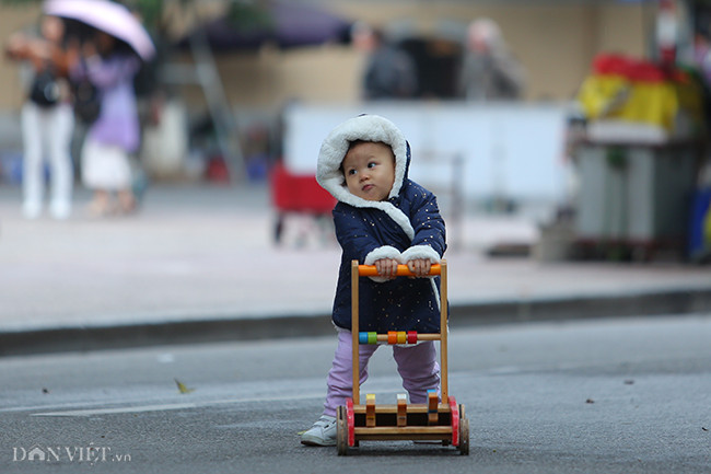 Quần áo kín từ đầu tới chân để chống chọi lại cái lạnh 12 độ C của một em bé tại quận Hoàn Kiếm.