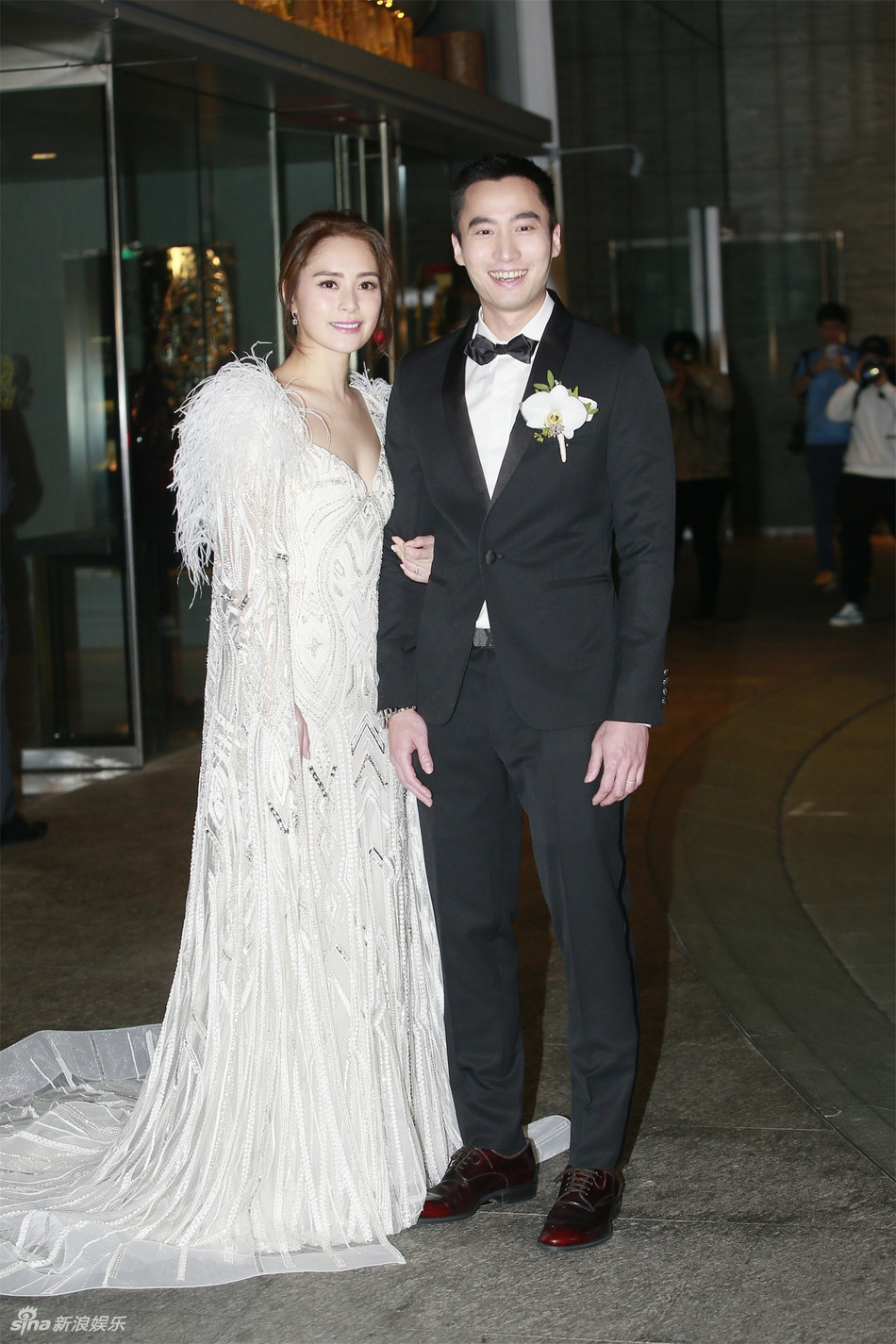 Thay vì chọn váy cưới truyền thống, Chung Hân Đồng xuất hiện gợi cảm trong mẫu váy xẻ ngực với phần đính kết lông vũ cầu kỳ ở vai. Trước đó, hôm 16/12, hai người hoàn tất thủ tục đăng ký kết hôn với sự chứng kiến của khoảng 30 bạn bè.