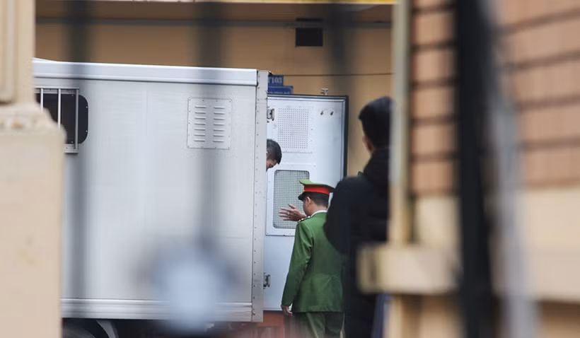 Các bị cáo lần lượt được cảnh sát dẫn giải từ trên xe thùng để vào phòng chờ.