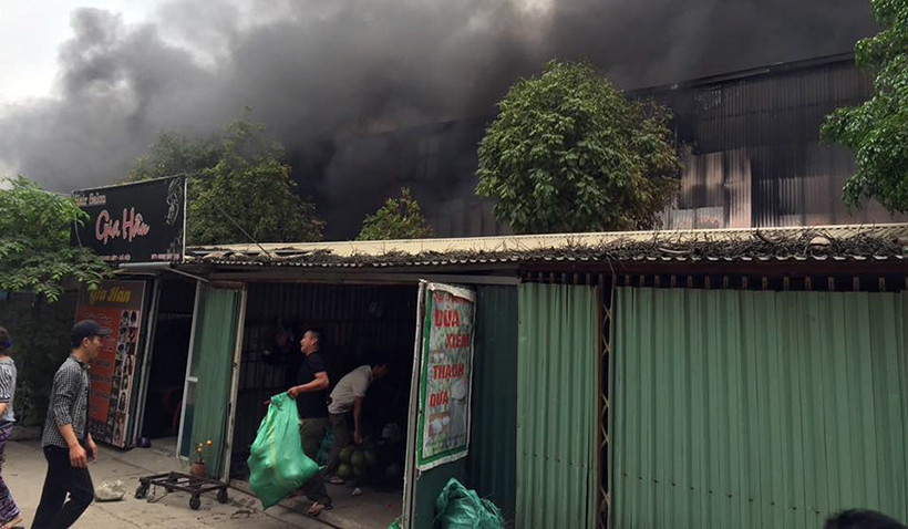 Một số chủ ki-ốt sát chợ khẩn trương di dời hàng hóa để tránh lửa cháy lan, gây thiệt hại.