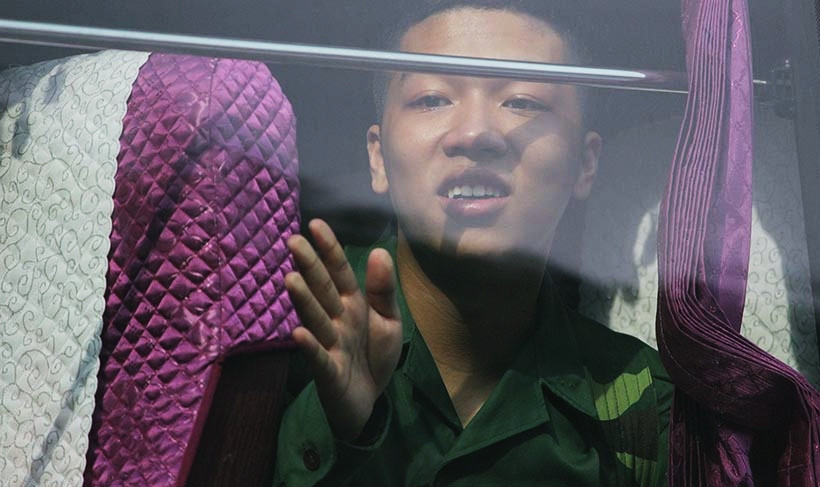 Chàng trai trẻ lưu luyến vẫy tay tạm biệt gia đình.