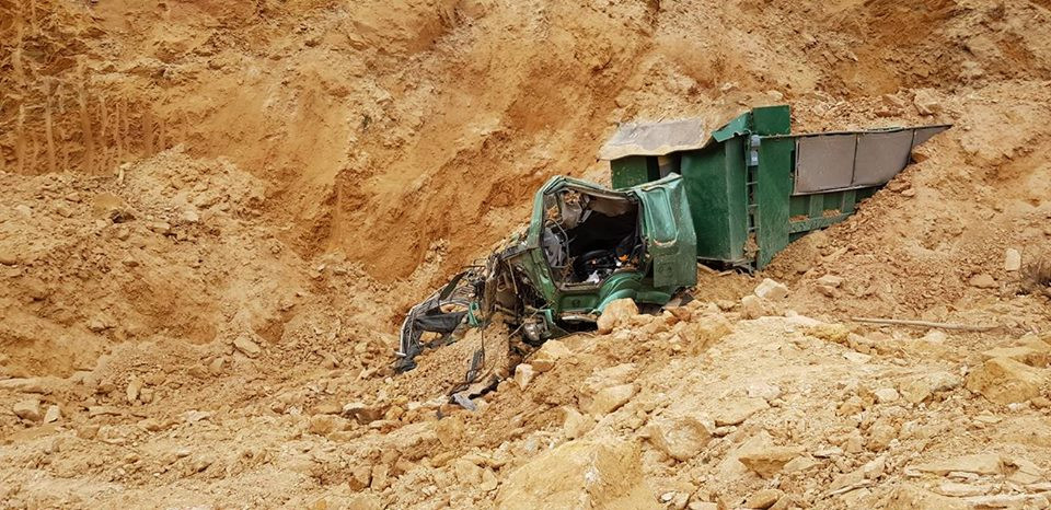 Cận cảnh chiếc xe ô tô bị đất vùi lấp bẹp dúm.