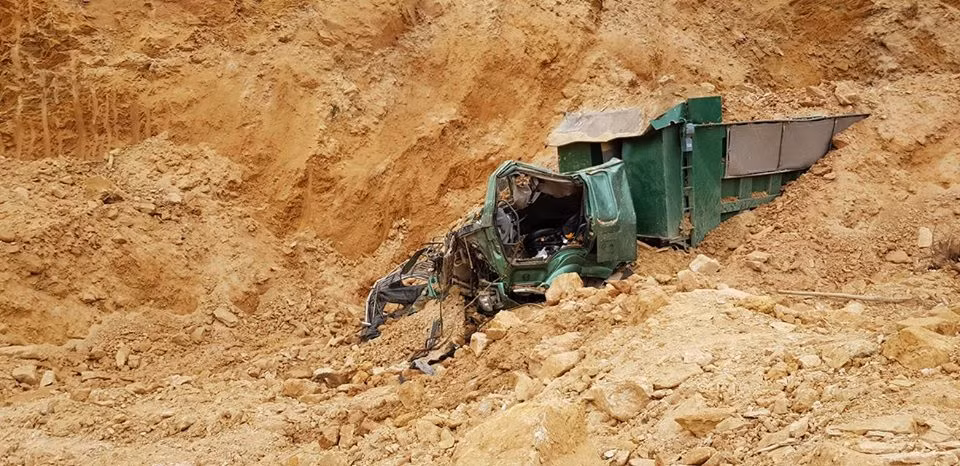 Cận cảnh chiếc xe ô tô bị đất vùi lấp bẹp dúm.