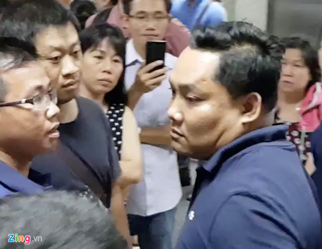 Người đàn ông to con (phải) được cho là đã có thái độ đe dọa người dân. Ảnh: Lê Trai.