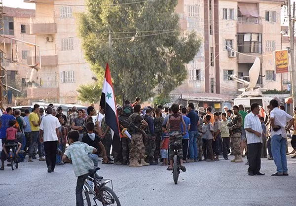 Những em nhỏ đạp xe gần một đám đông tập trung giữa đường phố. Ảnh: FNA.