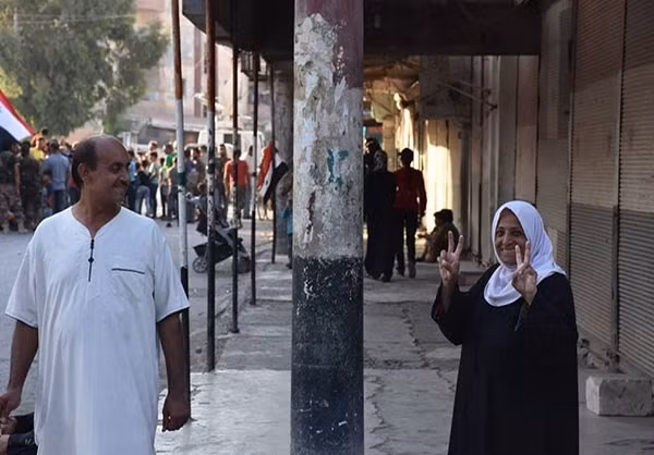 Người phụ nữ cười tươi làm biểu tượng chiến thắng trước ống kính trên đường phố Deir Ezzor. Ảnh: FNA.