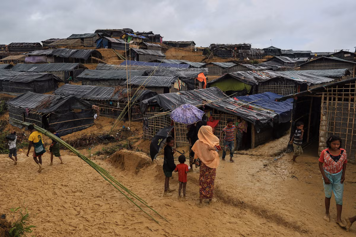Những người tị nạn Rohingya phải "lội" qua bùn đất mới vào được lán trại. Ảnh: AJ.