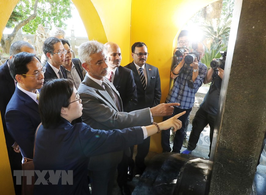 Bộ trưởng Ngoại giao Bùi Thanh Sơn và Bộ trưởng Ngoại giao Ấn Độ Subrahmanyam Jaishankar tham quan bia đá giới thiệu cây bồ đề do Tổng thống Ấn Độ Rajendra Prasad trao tặng Chủ tịch Hồ Chí Minh (năm 1959) được trồng tại chùa Trấn Quốc. (Ảnh: Lâm Khánh/TTXVN)