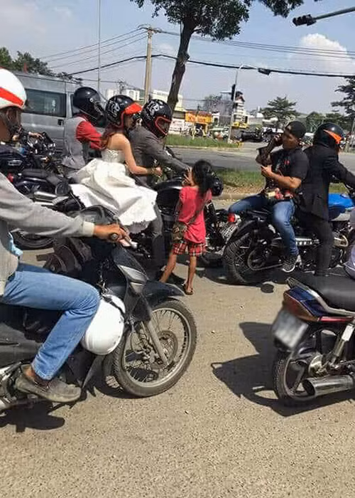 Hình ảnh cô dâu Khởi My ôm chặt chú rể Kelvin Khánh trong lễ rước dâu khiến nhiều người đi đường chú ý.