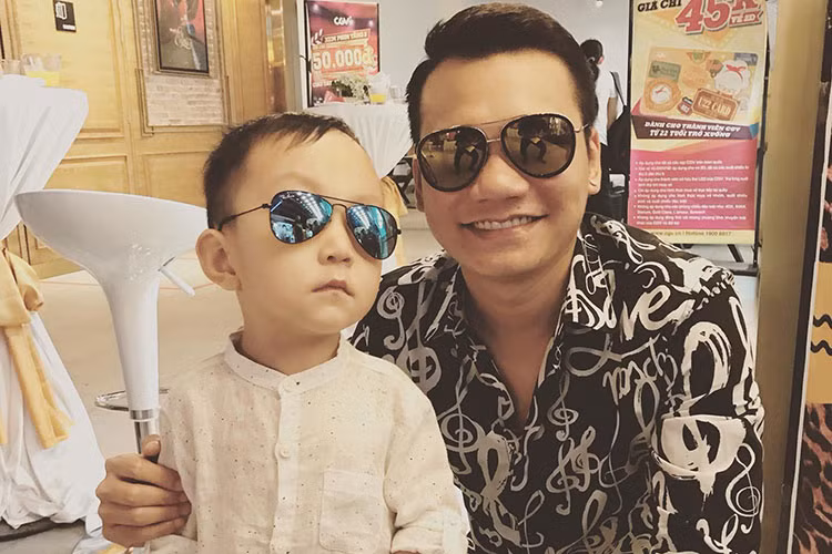Bé Su Hào - con trai của cặp đôi sao Việt Tuấn Hưng - Thu Hương đeo kính sành điệu chụp ảnh cùng Khắc Việt.