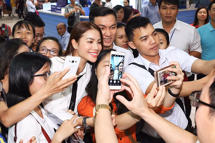 Tại sân bay Cam Ranh, Phạm Hương xuất hiện đầy rạng rỡ. Cô diện trang phục giản dị với đầm ngắn và áo trắng thắt cà vạt.