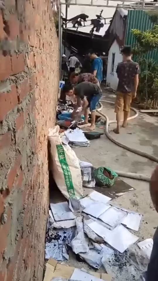 Nhiều vật dụng bên trong nhà xưởng nhanh chóng được đưa ra ngoài. Ảnh CTV.