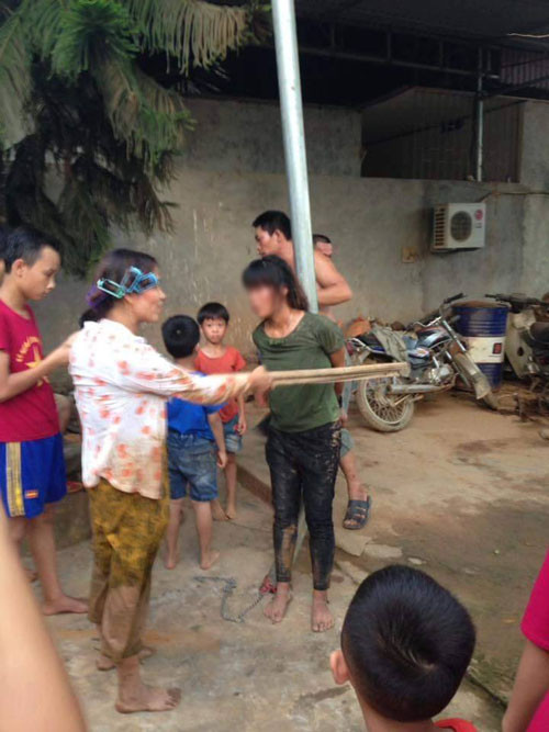 Cô gái bị người dân trói vào cột.
