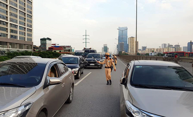 Cảnh sát phân luồng giao thông cho các phương tiện di chuyển trên đường Vành đai 3 trên cao. Hiện nguyên nhân xảy ra tai nạn đang được cơ quan chức năng làm rõ.