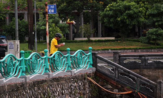 Người dân đi đường hiếu kỳ thấy cá lớn ở hồ Tây chết bèn dừng lại để theo dõi.
