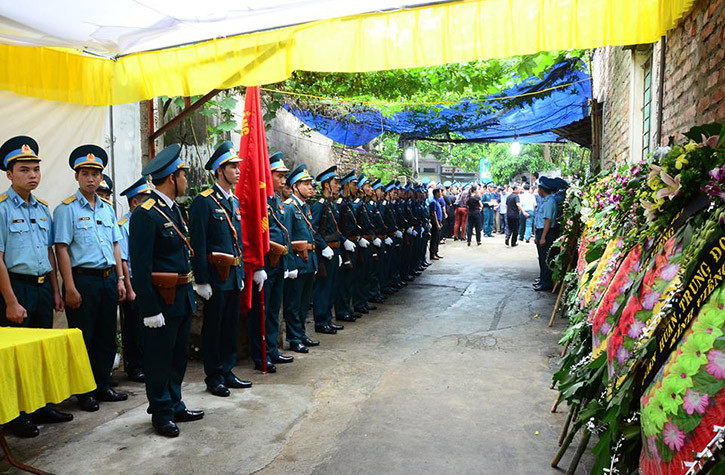 Hai bên đường từ ngoài vào phía trong nhà, đồng đội, người thân xếp hàng đón phi công máy bay Su-22 tài ba về nhà.