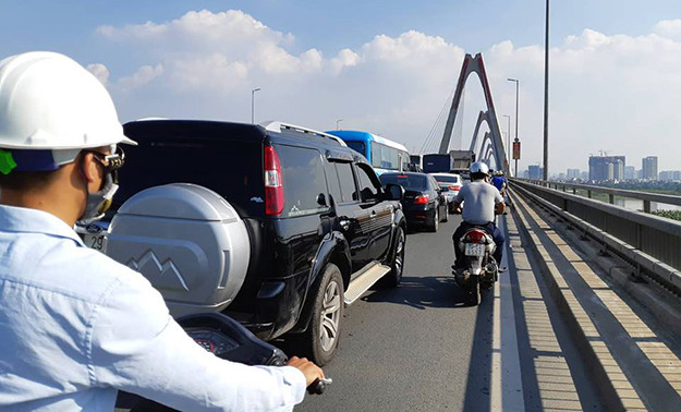 Tai nạn khiến chiếc xe tải lật ngửa, nằm chắn ngang cầu khiến các phương tiện tham gia giao thông qua đây ùn tắc.