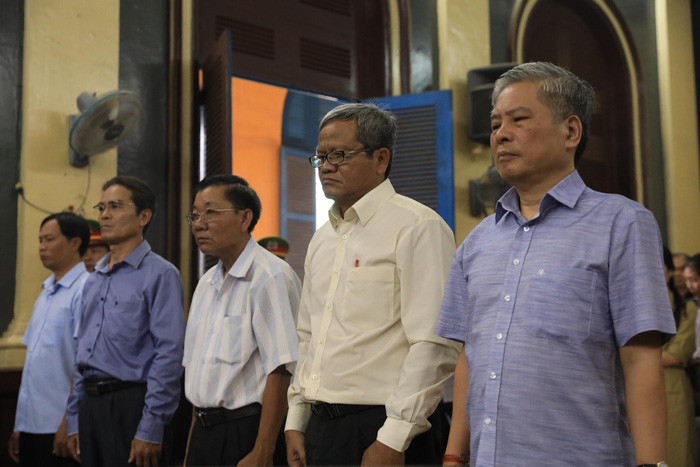 Các bị cáo đứng dậy nghe tòa tuyên án. Ảnh: Tuổi Trẻ.