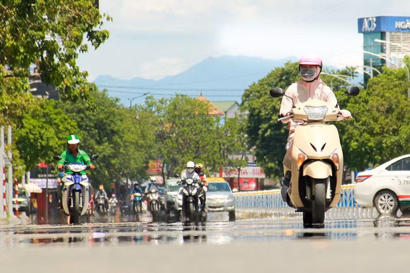 Nhiệt độ cao mang đến cảm giác mặt đường bị ướt, hình ảnh các phương tiện đi trên đường bị làm mờ, biến dạng. Ảnh: NGUYỄN DO