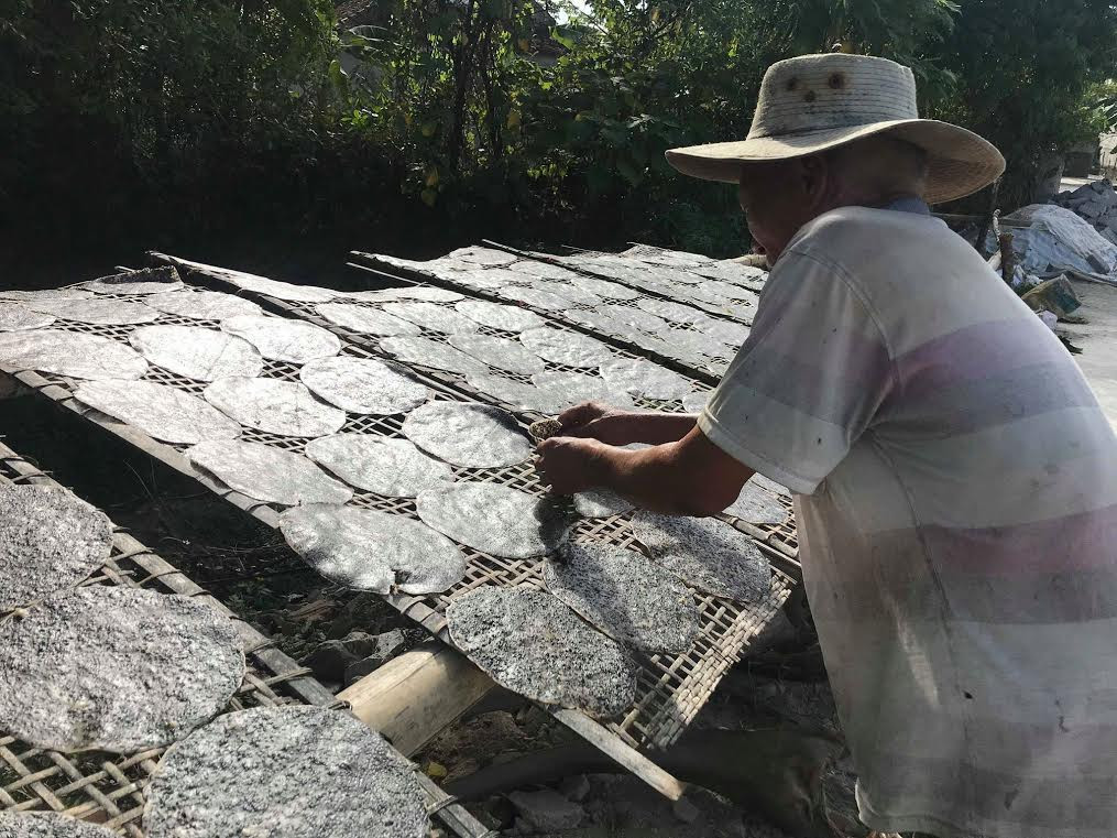 Dưới nắng nóng hơn 40 độ C, bà con vẫn luôn tay trở đều từng chiếc bánh để bánh được khô đều, không bị cong vênh. Ảnh: Mỹ Hà