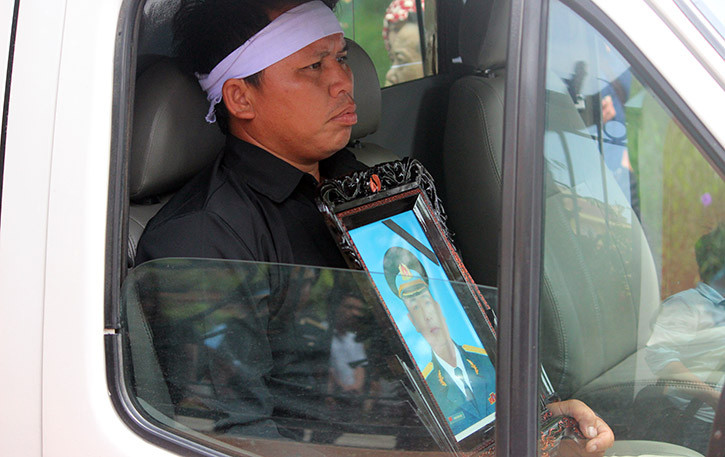 Người thân lặng lẽ ôm di ảnh Đại tá Phạm Giang Nam.