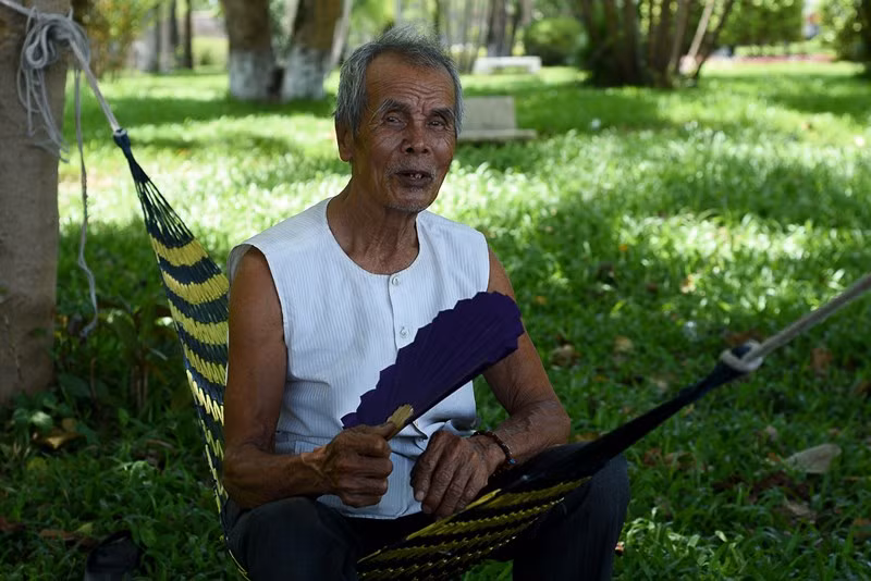 Cụ già ngồi nghỉ trưa bên sông Hương. Ảnh: NGUYỄN DO