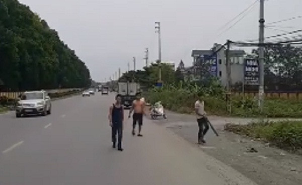 Nhóm thanh niên cầm theo hung khí chặn xe ô tô tải. Ảnh cắt từ clip.