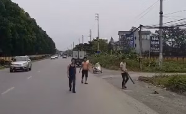 Nhóm thanh niên cầm theo hung khí chặn xe ô tô tải. Ảnh cắt từ clip.