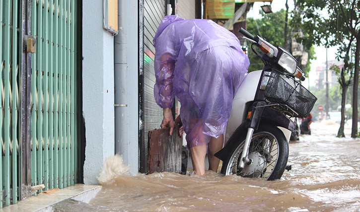 Các hộ dân dọc hai bên đường Vạn Phúc phải sử dụng các tấm ván, miếng bạt cùng những dụng cụ khác để chặn trước cửa, hạn chế nước ngập vào bên trong nhà.