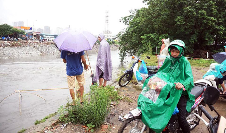 Một số người đi đường hiếu kỳ cũng dừng lại để xem người dân bắt cá.