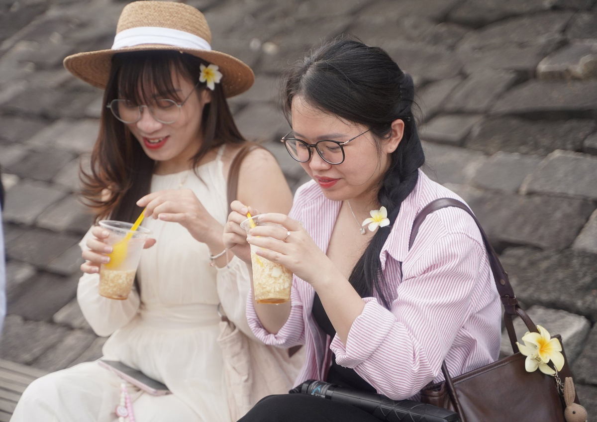 Nhiều bạn trẻ thích thú khi ngắm hoàng hôn và dùng đậu hủ bên dòng sông Hương thơ mộng. Ảnh: N.Q.