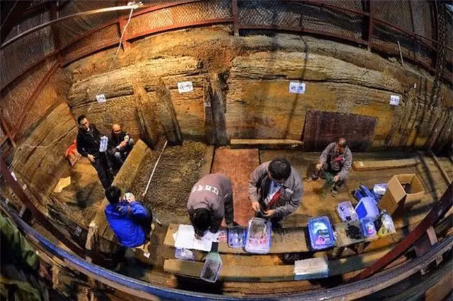 Khi dọn dẹp lăng mộ, các chuyên gia phát hiện một chiếc hộp màu cam.