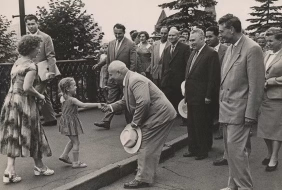 Nhà lãnh đạo Khrushchev nắm tay, trò chuyện với một bé gái khi đi dạo gần Điện Kremlin.