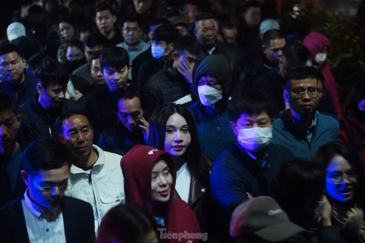 Lối vào sân đền cũng kín người. Lúc này, mưa bắt đầu đổ xuống nhưng không ngăn được sự thành tâm của người dân hướng về Đức Thánh Trần.