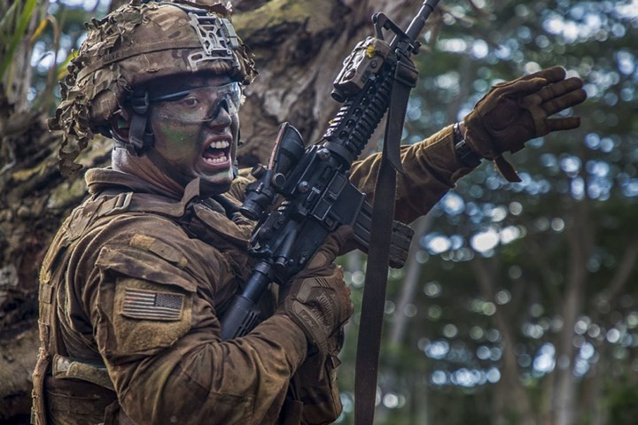 Một binh sĩ bộ binh Mỹ ra tín hiệu để đồng đội xông lên tấn công trong cuộc tập trận bắn đạn thật tại trại Schonfield, Mỹ.