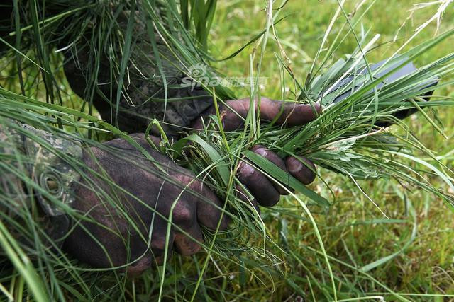 Binh lính Nga làm động tác vò cỏ để gắn lên người thành bộ quân phục ngụy trang. Nguồn ảnh: Sina.