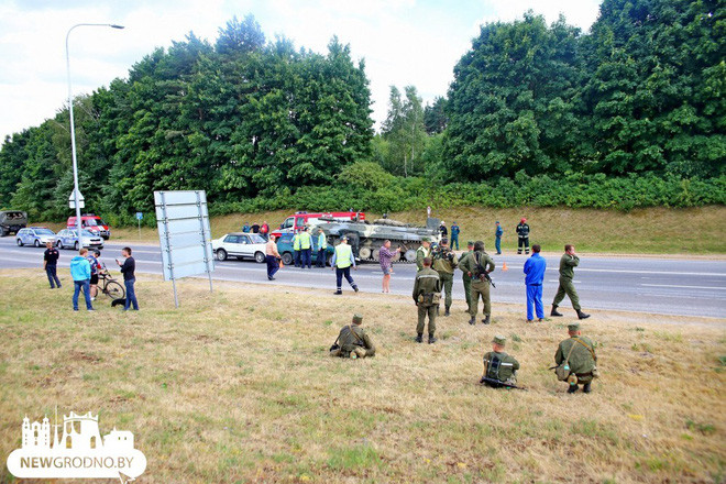 Các quân nhân Belarus ngồi bên vệ đường khi nhân viên Bộ Các tình trạng khẩn cấp Belarus xử lý hiện trường. (Ảnh: Newgrodno)