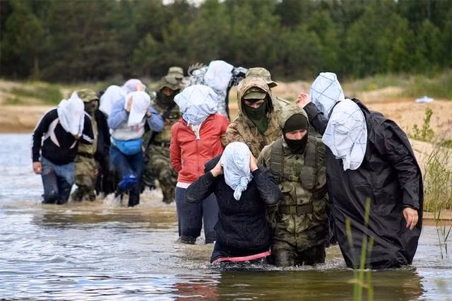 Những phóng viên bị chùm kín đầu và được áp giải đi theo tình huống bị khủng bố bắt cóc. Nguồn ảnh: Sina.