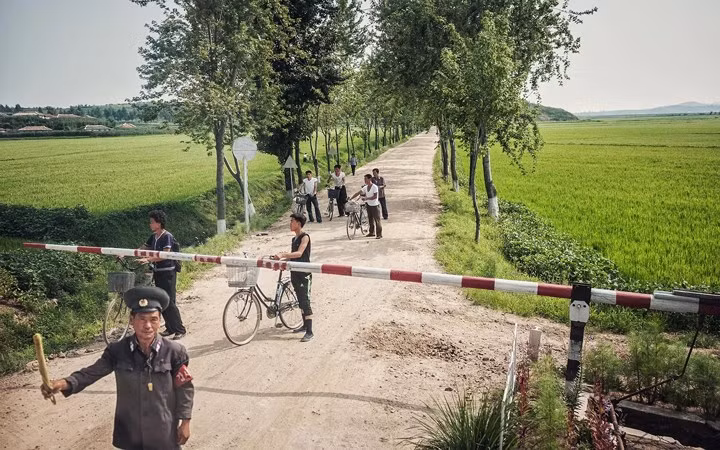 Người dân vùng nông thôn Triều Tiên chờ đi qua đường tàu.