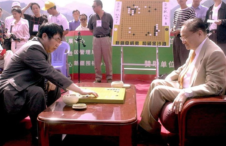 Nhà văn Kim Dung chơi cờ vây với kỳ thủ Nhiếp Vệ Bình tại Tân Cương ngày 5/8/2001.