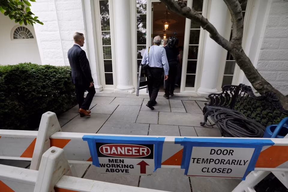Mật Vụ Mỹ đang hướng dẫn các nhà báo đến ghi chép về việc trùng tu Nhà Trắng. Biển báo nguy hiểm được dựng lên ở Vườn Hồng.