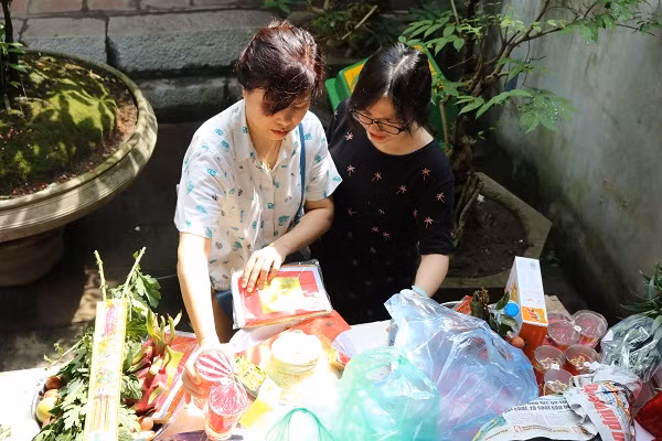 Hai mẹ con sĩ tử đang chuẩn bị đồ lễ để mang vào.
