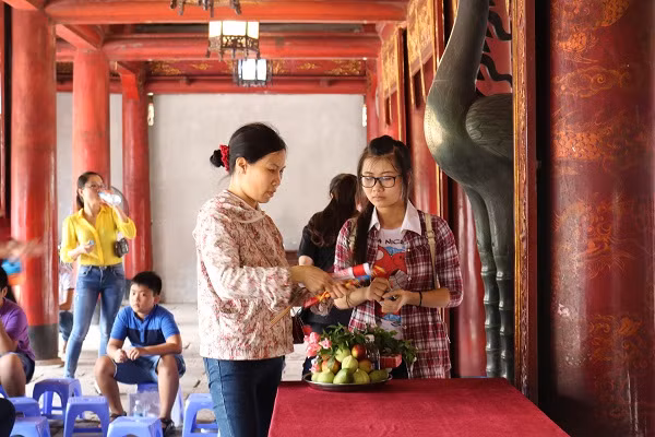 Em Đỗ Thị Ly cùng mẹ đang xếp lễ dâng lên. Hai mẹ con từ Hưng Yên lên Hà Nội sớm để chuẩn bị cho kỳ thi THPT Quốc gia 2016.