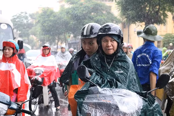 Hai mẹ con vất vả đội mưa đến làm thủ tục dự thi.