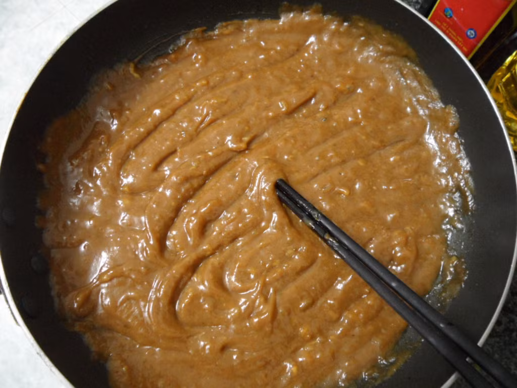 Nước sốt me. Nguyên liệu gồm: Me chín 500g, đường trắng 800g, nước mắm 50ml, ớt băm 20g, tương cà 30g. Me cho vào nước, bóp nhé cho tơi ra, ngâm khoảng 15-20 phút cho me nở. Sau đó bóp nhẹ tay để thịt rời khỏi hạt, lược bỏ hạt. Ảnh: Internet.