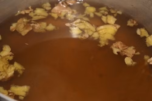 Khi nước đường sôi thì thả gừng đập dập vào nồi, để nước đường sôi lại khoảng 1-2 phút thì tắt bếp, chờ nước đường nguội. Ảnh: amthucbonmua