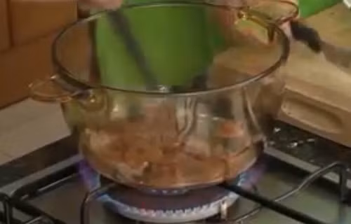 Bắc nồi lên bếp đun nóng dầu ăn và cho hành băm vào phi thơm. Kế đến cho tôm vào xào. Khi tôm chuyển màu thì cho vào một bát tô nước lọc. Ảnh: youtube