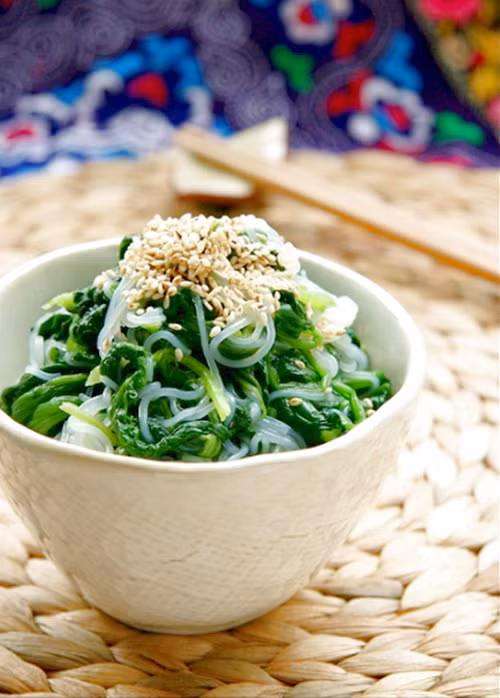 Rau cải trong bát miến được chần chín nhưng không bị nhũn và vẫn giữ được màu xanh mướt. Miến chần chín cho ra bát trộn đều cùng gia vị, dấm, đường, dầu vừng, ớt. Sau cùng cho rau cải vào rồi rắc vừng rang lên trên. Ảnh: biquyetgiamcan.