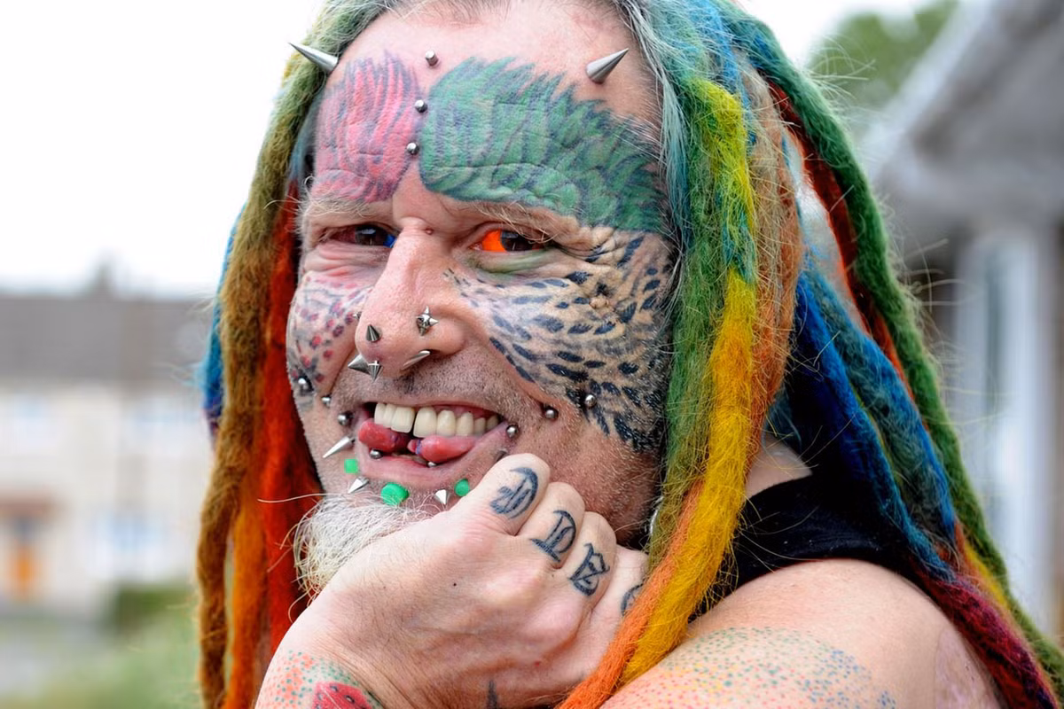 Ngoài hình xăm các kiểu, các màu, người đàn ông này còn có sở thích xỏ khuyên, đóng đinh trên mặt và xẻ lưỡi làm đôi. Chiến tích mới nhất là anh thay đổi màu của nhãn cầu. Lần này là một bên mắt màu đỏ và một bên mắt màu xanh.