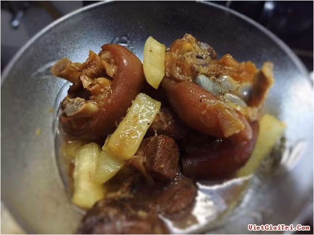 Để món móng giò kho giấm có màu sắc đẹp mắt, cho một muỗng canh đường vào xoong còn ít dầu để làm nước màu. Vặn lửa nhỏ, chờ đường tan và chuyển sang màu cánh gián thì cho giò heo vào. Trộn sơ cho giò heo săn lại rồi đổ giấm vào. Tuy kho giấm nhưng hãy yên tâm rằng món ăn của bạn sẽ không bị chua vì giấm chỉ có tác dụng làm cho giò mềm và thơm.